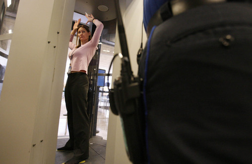 LEAH HOGSTEN | Tribune File Photo
In this 2009 photo, TSA program analyst and instructor Sherrie Soto (in pink) from Washington, D.C., stands in the Millimeter Wave Detection unit as SLC TSA security officers learn how to instruct airline passengers through the airports newest screening process.
