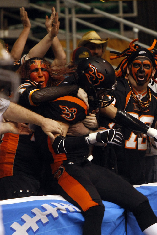 Photo by Chris Detrick | The Salt Lake Tribune 
Utah Blaze fans hug Blaze's Aaron Boone (1) after he scored a touchdown during the game at EnergySolutions Arena Thursday March 17, 2011.