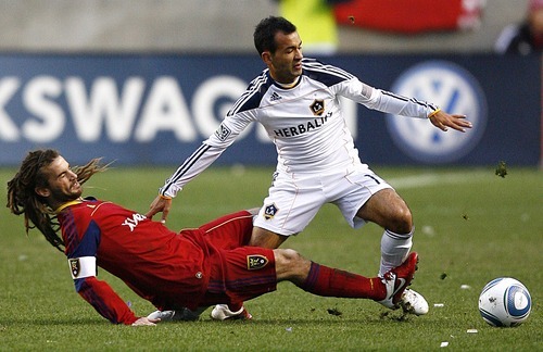 Djamila Grossman  |  The Salt Lake Tribune

Real Salt Lake's Kyle Beckerman (5), falls as he tries to kick the ball away from Los Angeles Galaxy's Juninho (19) during the first half of a game at Rio Tinto Stadium in Sandy, Utah, on Saturday,  March 26, 2011. RSL won the game.