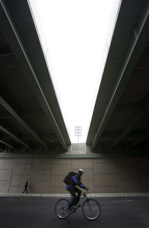 Francisco Kjolseth  |  The Salt Lake Tribune
A pedestrian and cyclist move along 600 East in Salt Lake under the I-80 corridor on Wednesday, March 30, 2011. Utah's highway bridges now rank among the safest in the nation, but still have room for improvement, says a new national report. The new safety status is in large part due to the recent highway improvements along the I-15, I-80 and the I-215 corridors.