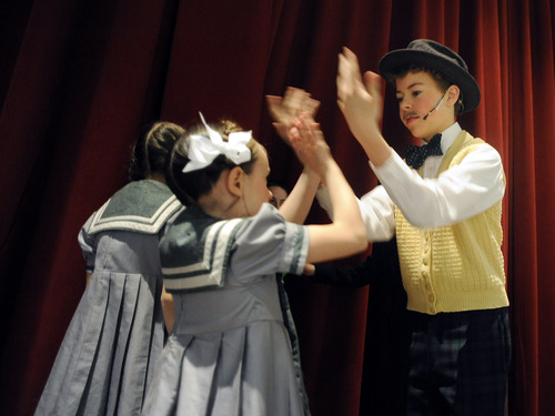 Sarah A. Miller  |  The Salt Lake Tribune

Sam Hallman, 14, plays a hand-clapping game with cast member Lilly Randall, 7, during some downtime before their performance of 