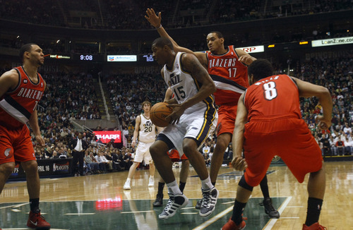 Photo by Chris Detrick | The Salt Lake Tribune 
Utah Jazz power forward Derrick Favors (15) grabs a rebound past Portland Trail Blazers center Chris Johnson (17) and Portland Trail Blazers point guard Patrick Mills (8) during the first half of the game at EnergySolutions Arena Thursday April 7, 2011.