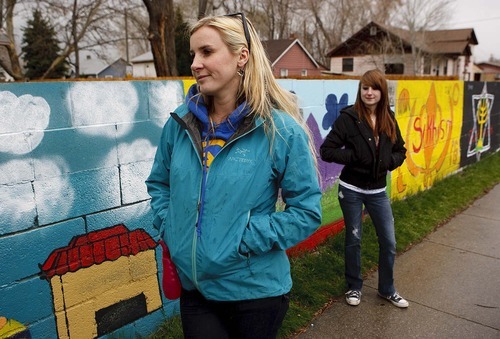 Trent Nelson  |  The Salt Lake Tribune
Jessi Cummings, left, a school teacher who lives in South Salt Lake, had a problem with gang graffiti on the wall surrounding her house. She decided to have some of her students at Taylorsville High paint over the graffiti with a mural of world religions. The mural has helped curb the graffiti problem on her wall. At right is Taylorsville High student Natalee Mathews.