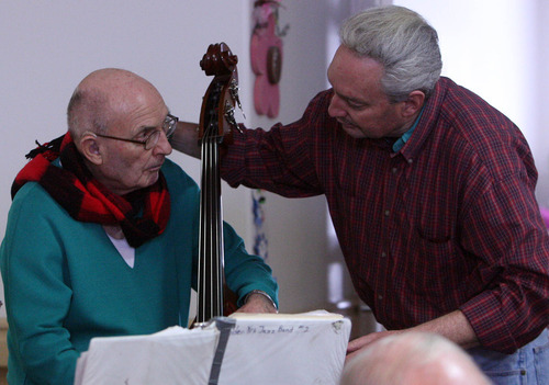 Leah Hogsten  |  The Salt Lake Tribune
Bassist Grant Morris gets his scarf rearranged by his son Randy Morris. The 89-year-old is one of the newer members of the Golden Years Jazz Band. Morris had not played an instrument for 60 years until about eight months ago, when he told his son he wanted to play. Randy bought him a string bass, and Morris was able to play in perfect key.