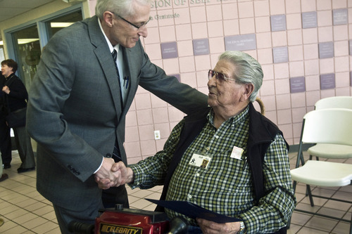 Chris Detrick | The Salt Lake Tribune 
Utah Lt. Gov. Greg Bell honors 86-year-old Paul Soria at The Road Home on Wednesday April 13, 2011. Soria is a World War II veteran and employed as a front desk monitor for the homeless shelter.