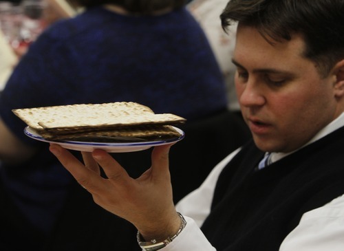 Rick Egan   |  The Salt Lake Tribune

A prayer is said as Justin Jones holds up  the plate of matzah  during a Seder service at the WIlkinson Center at Brigham Young University, Saturday, April 9, 2011.  For nearly 40 years, BYU professor Victor L. Ludlow,  a specialist in Jewish studies, has been conducting the celebrations at BYU.