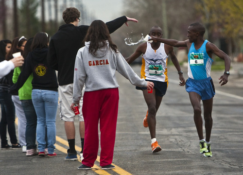 Photo by Chris Detrick | The Salt Lake Tribune 
Joseph Mutinda, front, and Jonathan Ndambuki grab water during the 2011 Salt Lake Marathon Saturday April 16, 2011. Ndambuki won the marathon with a time of 2:25.56.