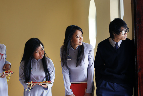 Scott Sommerdorf  |  The Salt Lake Tribune
Young members of the Lien Hoa Buddhist Temple look out the front door to see if the ribbon cutting ceremony they are helping with is about to begin. The Temple opened Sunday after a decade of planning in West Valley CIty Sunday, April 17, 2011.