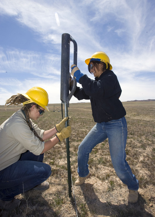 Al Hartmann   |  The Salt Lake Tribune 
Cassidy Green, of Puyallup, Wash., left holds a steel post in place while Lora Peña of Prescott, Ariz., pounds it into the ground as they build a fence for the Bureau of Land Management in open grazing country just south of I-70 near Moab on Monday, April 11.  They are members of the Canyon Country Youth Corps. President Obama's outdoor initiative calls for more outdoor jobs for youths.