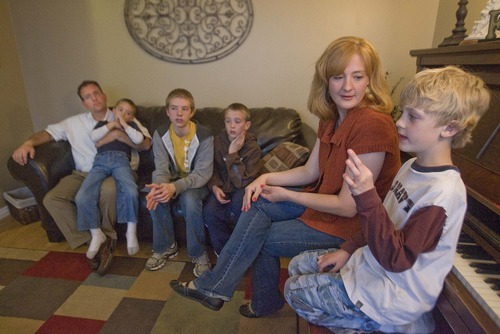 Paul Fraughton  |  The Salt Lake Tribune
In the living room of their Sandy home, the Scheffner family discusses education. Father, Gary is holding kindergardener Zach, Ben, in seventh grade, Sam in fourth grade, Mom Jennifer listens to Jake, who is in second grade.