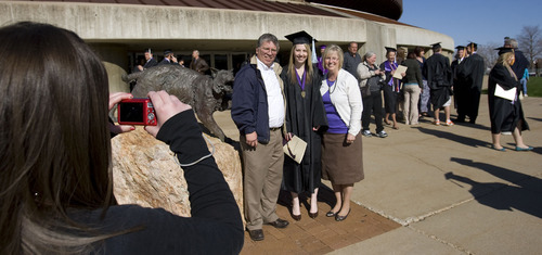 Al Hartmann  |  The Salt Lake Tribune 
Samantha Rushton, left, takes a picture of her father Jeff, sister and new Weber graduate Allison and her mother Hazel Rushton outside the Dee Event Center on Friday, April 22, after the university's 137th commencement.