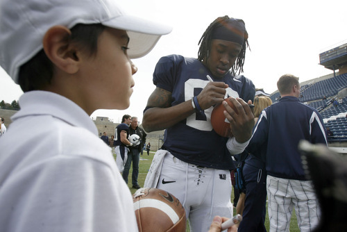 Francisco Kjolseth  |  The Salt Lake Tribune
Aggie fan Desmond Phillips, 8, gets his football signed by Travis Reynolds as following Utah State's Spring football game on Saturday, April 23, 2011, at Romney Stadium in Logan in front of the Aggie fans.