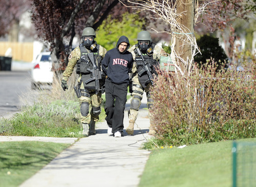 Sarah A. Miller  |  The Salt Lake Tribune

SWAT team members walk with Arturo M. Chavez, 32, after he left a home he was staying at on Westwood Ave. Thursday morning April 28, 2011 in Salt Lake City. Police, SWAT and JCAT had been on the scene since midnight waiting for Chavez who had a warrant out for his arrest on the third degree felony drug charge. Chavez was arrested Thursday morning.