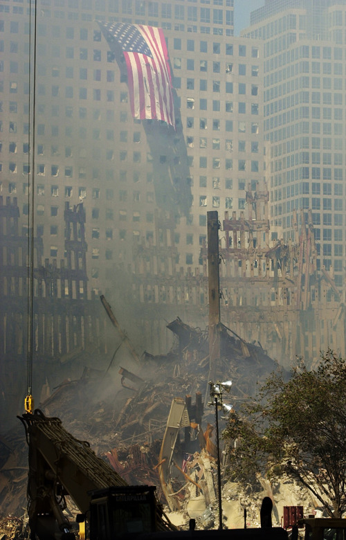 A giant American flag flies from the American Express building in New York Sunday, Sept. 16, 2001, overlooking the smoldering rubble of Tuesday's World Trade Center terrorist attack. (AP Photo/Charles Rex Arbogast)