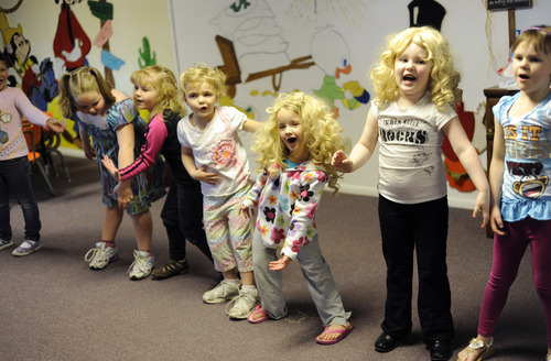 Sarah A. Miller  |  The Salt Lake Tribune
Preschoolers Ava Solberg, 5, center, and Hallie Shaw, 4, right, wear wigs as they practice singing and dancing for an upcoming musical program at Aunt Sands' Preschool in West Valley City. Aunt Sands' received the Essential Piece award from the city for being an essential piece of the community for 31 years.