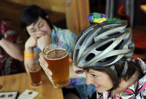 Sarah A. Miller  |  The Salt Lake Tribune

Shauna Mabey of Bountiful lifts her glass of beer to the parrot on her bike helmet while at Squatters Pub Brewery during the second annual Tour de Brewtah March Saturday May 7, 2011 in Salt Lake City. Four hundred bicyclists participated in the event to raise funds for Splore, Utah Clean Energy and Cottonwood Canyons Foundation. Bicyclists were given tickets to try different local beers at several area bars. They were encouraged to register as a team and dress in costume. Pictured in the background is Lindsay Cleverly of Salt Lake City. They called their group the Parrotheads.