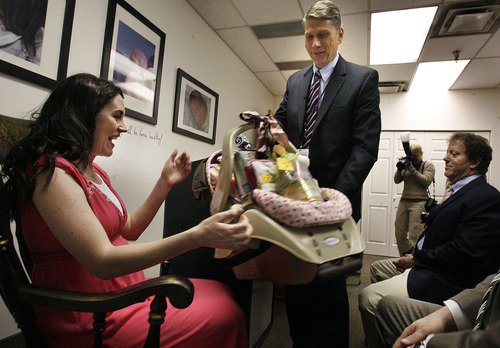 Scott Sommerdorf  |  The Salt Lake Tribune
Expectant mother Sarah Reeder is excited to get an infant carseat and other baby items, presented by Daron Cowley of Intermountain Healthcare, at a press conference in Salt Lake City on Thursday. The University of Utah and Intermountain Healthcare announced a study of  first-time mothers to help identify what women will be at risk of pregnancy complications.