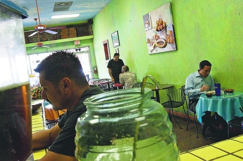 DJAMILA GROSSMAN  |  The Salt Lake Tribune
Jesus Vasquez works on the counter as a few people eat in the back, at Mangos Restaurant in Mesa, Ariz. Many local businesses claim of a dropoff in customers -- a downturn some blame on the state's year-old immigration enforcement law.