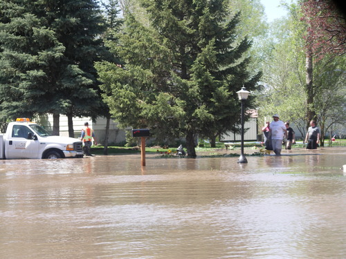 Arrin Newton Brunson  |  The Salt Lake Tribune
Floodwater from the Blacksmith Fork River breached a sandbag levee at approximately 9:50 a.m. Sunday, filling the streets, including Country Manor Drive, shown here, and several homes in Country Manor Subdivision in south Logan. City officials turned off the power to prevent electrocution and ordered the evacuation of residents in 65 homes. The levee was repaired by noon; the water receded and the evacuation was lifted at 2 p.m.