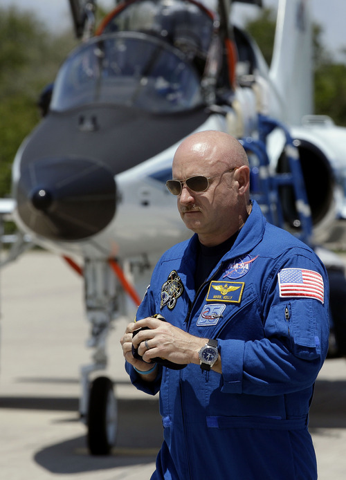 FILE - In this April 26, 2011 file photo, Mark Kelly, commander of the space shuttle Endeavour, walks past a T-38 jet after arriving at Kennedy Space Center with his fellow crew members in Cape Canaveral, Fla.  Kelly's wife, Arizona congresswoman Gabrielle Giffords, left Houston for Cape Canaveral late Wednesday morning, April 27, 2011 to watch the liftoff of the space shuttle Endeavour, scheduled for Friday afternoon. (AP Photo/Chris O'Meara, File)