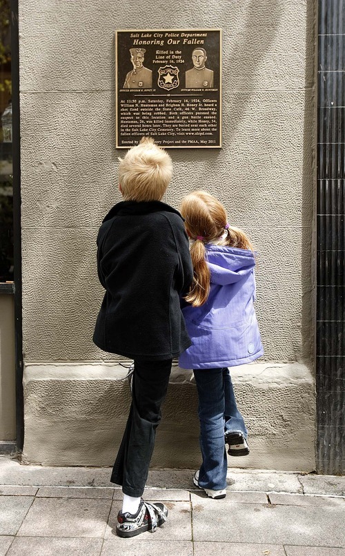 Trent Nelson  |  The Salt Lake Tribune
Jackson Del Quadro, left, and Kylee Snow, great-great-grandchildren of slain Salt Lake City police officer Brigham Honey, look at a new plaque honoring two officers who were killed in the line of duty in 1924.