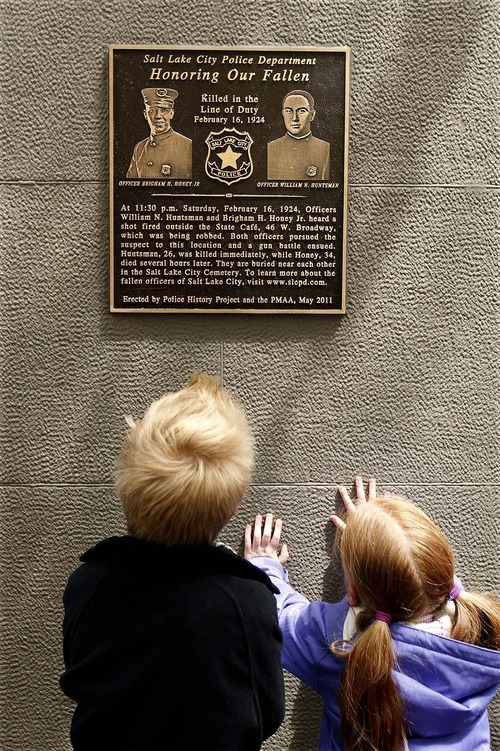 Trent Nelson  |  The Salt Lake Tribune
Jackson Del Quadro, left, and Kylee Snow, great-great-grandchildren of slain Salt Lake City police officer Brigham Honey, look at a new plaque honoring two officers who were killed in the line of duty in 1924.