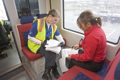 PAUL FRAUGHTON  |  The Salt Lake Tribune 
TRAX train drivers D J Birch, left, and JoAnn Sloan study  information about the train lines set to open Aug. 7  as they ride on a test run on the Mid-Jordan line.