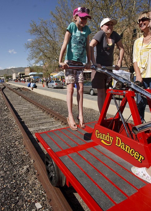 Trent Nelson  |  The Salt Lake Tribune
Ardem Tesch, left, and Sarah Frasier put some muscle into powering the Candy Dancer handcart along the train tracks at the Granary District Block Party in Salt Lake Cit on Saturday. At right is Anne Alder, along for the ride.