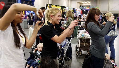 Trent Nelson  |  The Salt Lake Tribune
Mothers take photos of their children posing with Ryan Simmons, dressed as a Star Wars scout trooper, at the Utah Baby and Kidz Expo at the South Towne Expo Center in Sandy. Simmons and other members of the Alpine Garrison volunteer their time dressing up in Star Wars costumes to entertain children and raise money for charities.