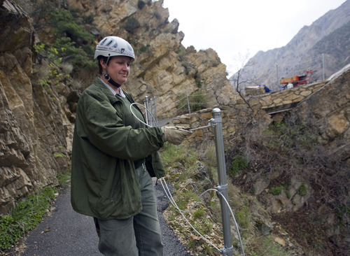 Al Hartmann  |  The Salt Lake Tribune
Timpanogos Cave National National Monument maintenance worker Ranae Brown threads steel cable between posts to construct a fence along an exposed part of the trail to the cave in American Fork Canyon.