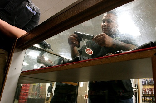 Leah Hogsten  |  The Salt Lake Tribune
Felipe Garcia looks for a Ruger .9mm in the pistol cases of Doug's Shoot 'N Sports on Saturday in Taylorsville. Sales of guns at gun shops in Utah are closely regulated, but those selling firearms over the Internet through classifieds have few restrictions or regulations.