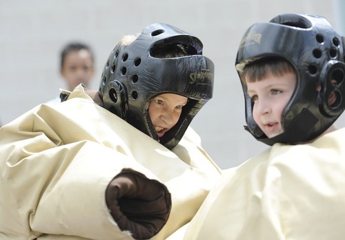 Sarah A. Miller  |  The Salt Lake Tribune

Greysen Johnson, 8, left, and Paul Lykins, 6, right, both of Salt Lake City, sumo wrestle at the third annual CommUNITY Fair held at the Sorenson Unity Center in Salt Lake City on Friday. he event celebrated the cultural diversity and unique community of the Glendale and Poplar Grove areas. The event also served as the kick-off for the newly created Unity Gardens, a 24-plot community garden located behind the center.