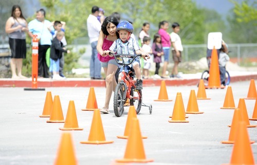 Sarah A. Miller  |  The Salt Lake Tribune

Estefani Estrada, 11, helps her brother Arturo, 4, ride through a cone obstacle course at the third annual CommUNITY Fair held at the Sorenson Unity Center in Salt Lake City on Friday. he event celebrated the cultural diversity and unique community of the Glendale and Poplar Grove areas. The event also served as the kick-off for the newly created Unity Gardens, a 24-plot community garden located behind the center.