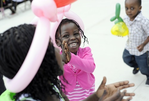 Sarah A. Miller  |  The Salt Lake Tribune

Alina Joseph, 3, of Salt Lake City, dances with her sister Evana Joseph, 6, left, and cousin Daniel Sannoh, 2, right, after getting balloon hats at the third annual CommUNITY Fair held at the Sorenson Unity Center in Salt Lake City on Friday. he event celebrated the cultural diversity and unique community of the Glendale and Poplar Grove areas. The event also served as the kick-off for the newly created Unity Gardens, a 24-plot community garden located behind the center.