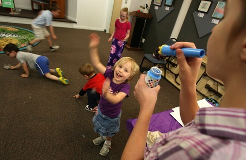 Leah Hogsten  |  The Salt Lake Tribune
Courtney Carpentier and other children with autism laugh and play as Courtney's sister Megan, 12, blows bubbles. A dozen or more children with autism, their parents and siblings enjoyed an hour of Special Needs Sensory Story Time at the Kearns Library on Saturday.