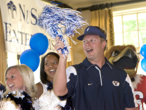 Al Hartmann  |  The Salt Lake Tribune
BYU football coach Brono Mendenhall, whose blue team lost at the Liberty Mutual Invitational to the red Ute team, sings the Utah fight song in consolation but still waves a blue and white pompom.  He gets help from the BYU and Utah cheerleaders and team mascots.  The benefit golf tournament was held at the Salt Lake Country Club on Monday, June 6.