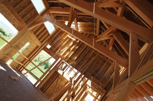 Kim McDaniel | The Salt Lake Tribune
Great room with a two story ceiling, large beams and cables. Three transom windows line both front and back, and full-height windows surround the room.