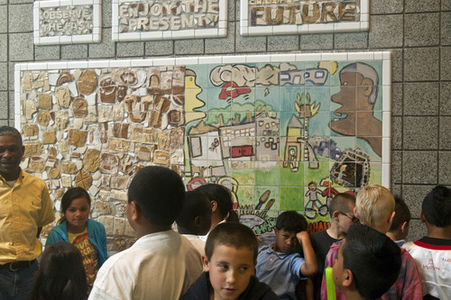 Chris Detrick  |  The Salt Lake Tribune 
Students at Riley Elementary look Tuesday at the mural they made.  About 55 students spent time making the mural, which aims to break stereotypes about their Glendale neighborhood. At left is Lynn Green, coordinator of the school's after-school program.