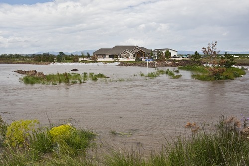 Photo by Chris Detrick | The Salt Lake Tribune 
Water from the Weber River floods near homes in West Warren on Thursday, June 9, 2011. Around 7:30 a.m., Weber County officials were gasing up diesel pumps used to divert the waters when they saw the levee break. Three of the pumps are now submerged and by noon, floodwaters near the levee were a foot above flood stage and climbing.