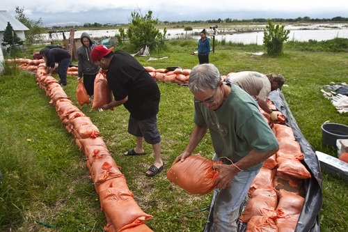 Photo by Chris Detrick | The Salt Lake Tribune 
Jim Bond helps to pile up sand bags around a home as the Weber River flood in West Warren Thursday June 9, 2011.