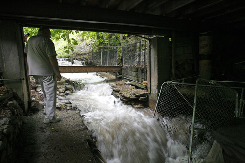 Rick Egan   |  The Salt Lake Tribune
Ed Remund watches the water flow under his cabin that straddles Red Butte Creek Monday. The high water has been washing away sandbags that have been in place since 1983, many of which were stained by oil during last year's spill. He is among a group of residents who, miffed at Chevron over filed claims, have turned to a lawsuit.