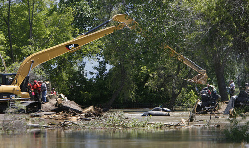 Francisco Kjolseth  |  The Salt Lake Tribune
Weber County's Incident command manages repairs to a broken levee along the Weber River in West Warren on Friday, June 10, 2011, with help from the Utah National Guard and contractor Randy Marriott Construction. Two black hawk helicopters were brought in to move large sand bags into the area while ground crews try to shore up the area that breached to hold the bags in place.