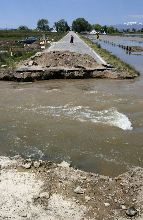 Francisco Kjolseth  |  The Salt Lake Tribune
Water flows along West Warren's 5900 West on Friday, June 10, after the road was cut to try and relieve pressure created when a levee broke along the Weber River.