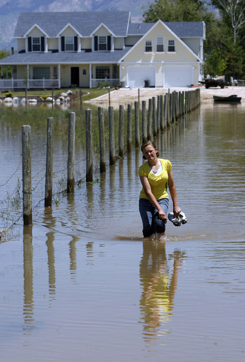 Francisco Kjolseth  |  The Salt Lake Tribune
Tacy Hardy, 14, of West Warren and her family feel lucky to at least have their house above water as she walks the length of her driveway under water. Weber County's Incident command manages repairs to a broken levee along the Weber River in West Warren on Friday, June 10, 2011, with help from the Utah National Guard and contractor Randy Marriott Construction. Two black hawk helicopters were brought in to move large sand bags into the area while ground crews try to shore up the area that breached to hold the bags in place.