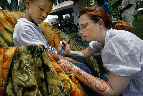 Scott Sommerdorf  |  The Salt Lake Tribune
Angela Crabtree works on a henna design on the arm of six year old Jackson Heath at her 