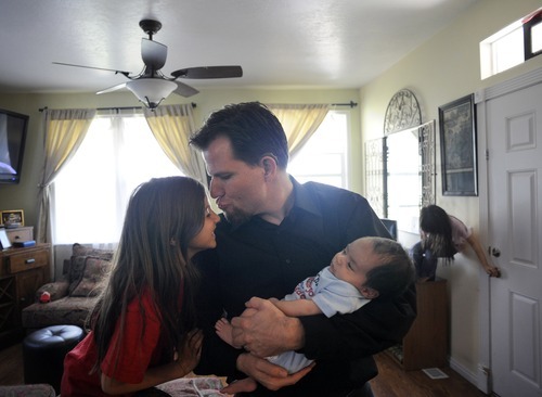 Sarah A. Miller  |  The Salt Lake Tribune

Adam Schafer kisses his daughter Eva, 8, as he holds his six-week-old son Michael inside his Daybreak neighborhood home in South Jordan Tuesday May 31, 2011. Schafer lost his job last year, and now the family is facing foreclosure.