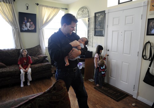 Sarah A. Miller  |  The Salt Lake Tribune

Adam Schafer holds his six-week-old son Michael inside his Daybreak neighborhood home in South Jordan Tuesday May 31, 2011. Schafer lost his job last year, and now the family is facing foreclosure.