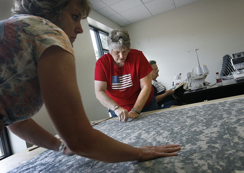 Scott Sommerdorf  |  The Salt Lake Tribune
Jackie Bulloch of Cedar City helps lay out the fabric that will become a quilt to be sent to soldiers in the Utah National Guard's 222nd Field Artillery Unit. She has organized a project to make quilts from special Army-issued camo fabric. She and other sewing volunteers worked at the 222nd Armory in Richfield on Monday.