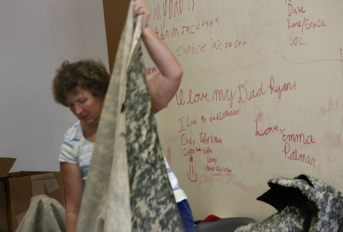 Scott Sommerdorf  |  The Salt Lake Tribune
Messages scrawled on a white board by children of National Guardsmen serving with the 222nd can be seen in one of the rooms where volunteers are making quilts for the unit. Jackie Bulloch, a Cedar City woman who has three grandsons and a nephew in the Utah National Guard's 222nd Field Artillery Unit, has organized a project to make quilts from special Army-issued camo fabric. She and other sewing volunteers work at the 222nd Armory in Richfield on Monday.
