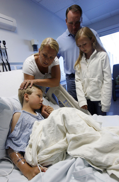 Francisco Kjolseth  |  The Salt Lake Tribune
Six-year-old Cody Grundstrom of Hudson, Wis., is comforted by his mother, Jenney, father, Kevin, and sister, Madison, 10.